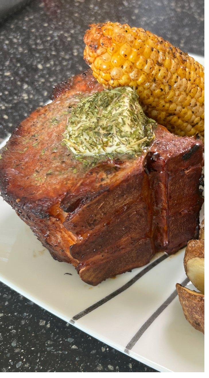 Smoked pork chop with herb butter and grilled corn